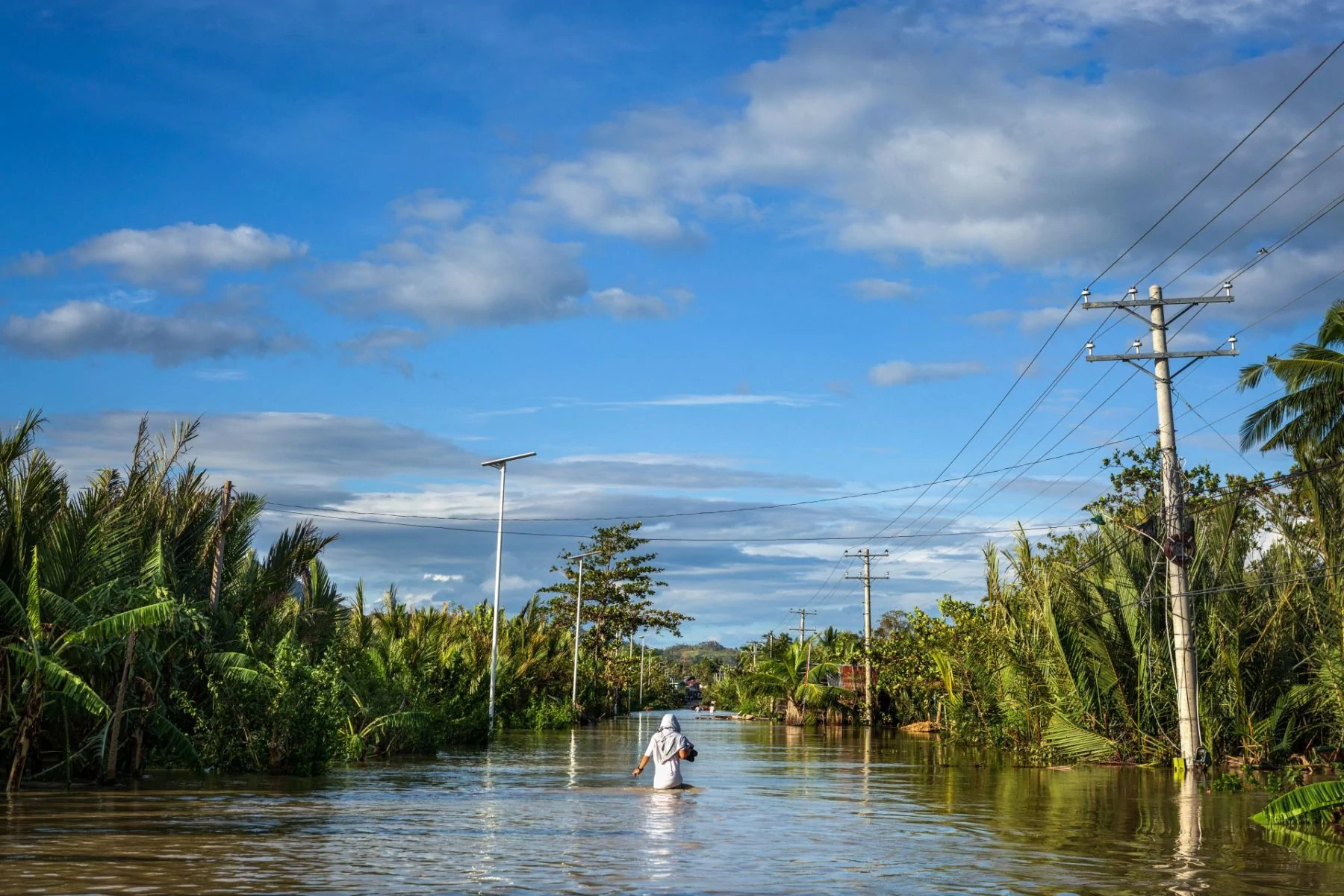 A solitary person wades in floodwaters after Typhoon Rai in Philippines