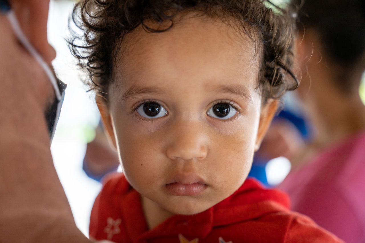 A very young patient watches intently