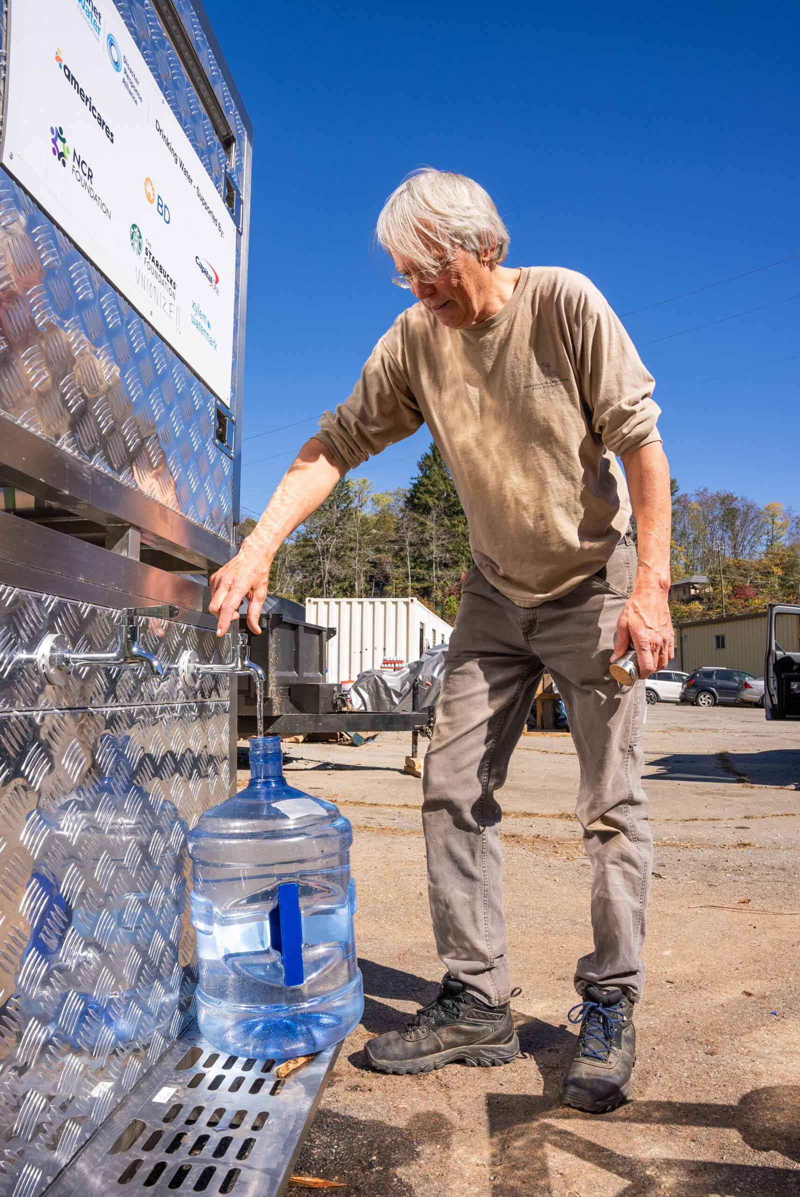 Water flows from an Aqua Block water filtration system into a water jug for Jon, a resident of Asheville, North Carolina.  (Photo/Americares)