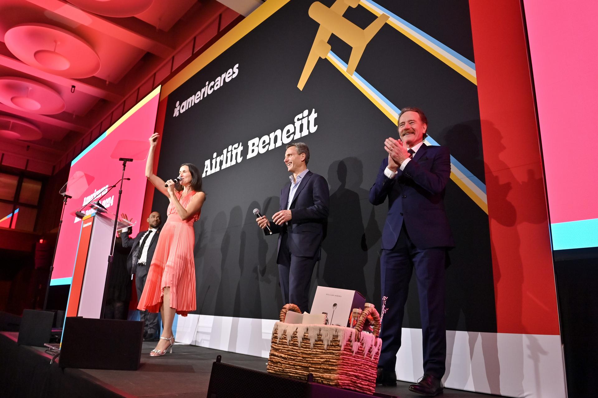 Lydia Fenet Agency Founder and CEO Lydia Fenet, Americares Board Member Tony Goldwyn and Master of Ceremonies Bryan Cranston on stage at the 2024 Americares Airlift Benefit. Photo by Bryan Bedder/Getty Images for Americares.