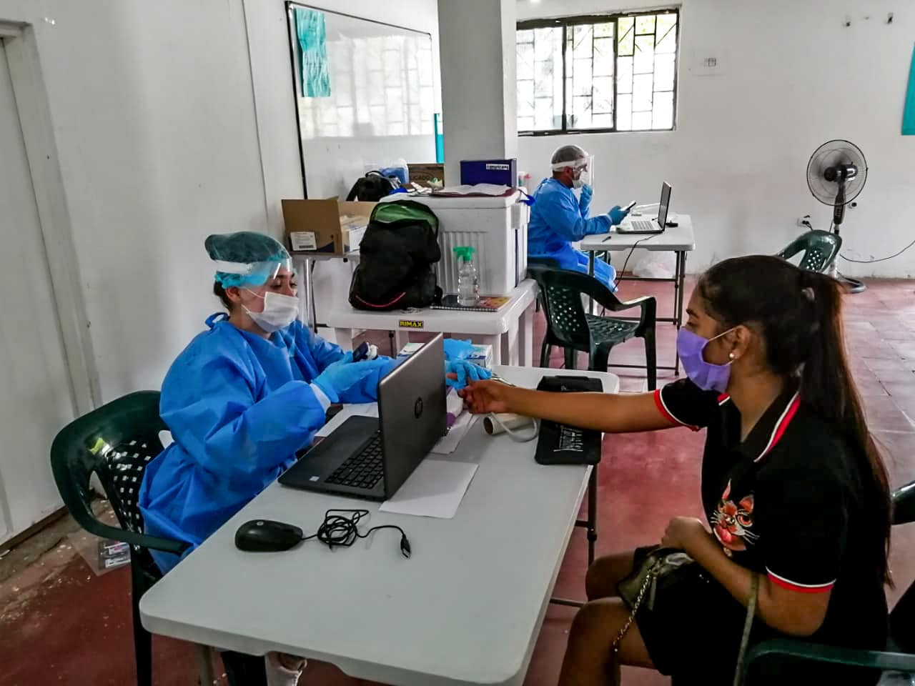 Head nurse interviewing patient sitting at a table in Colombia clinic