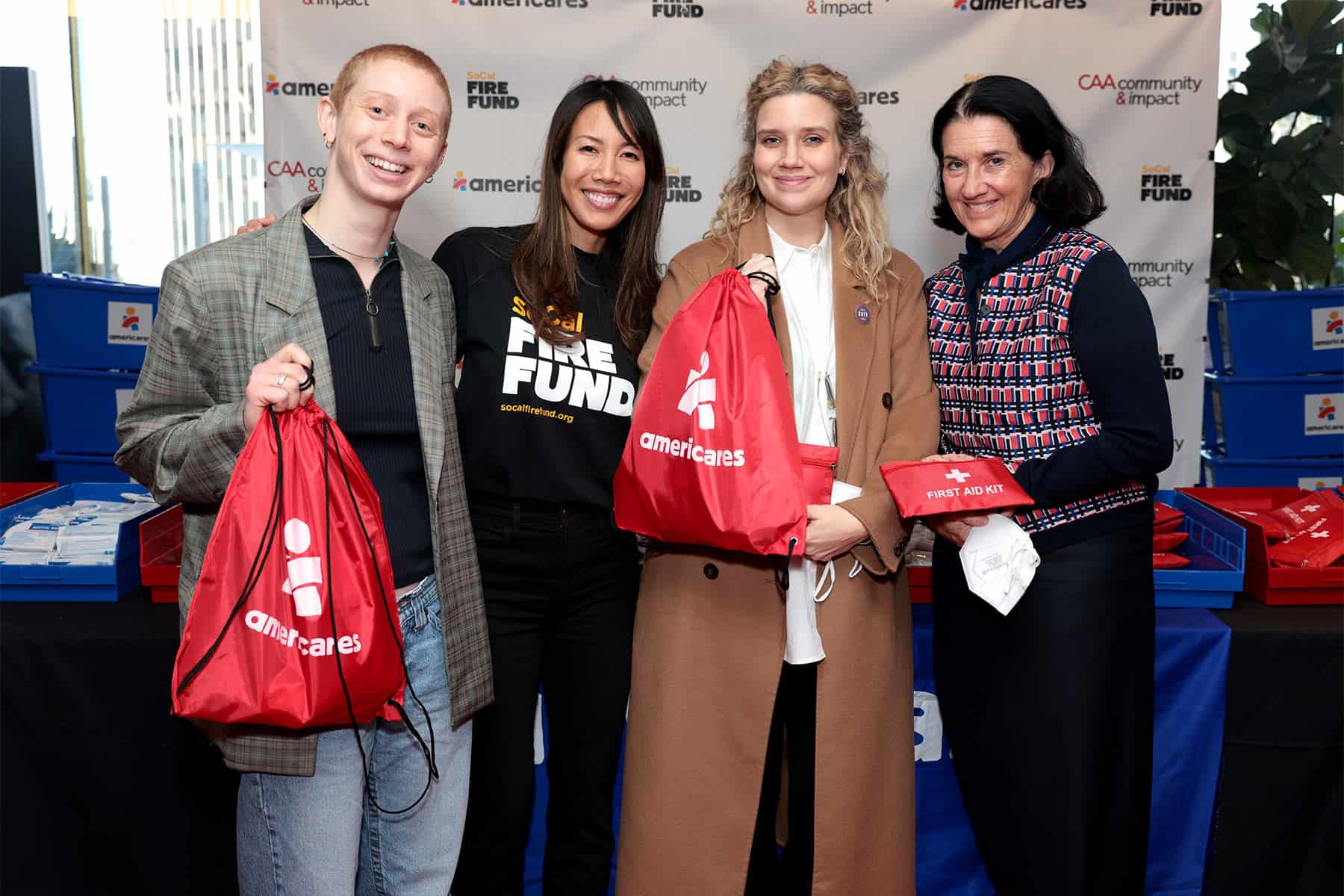 Natalie Tran (2nd from L) and Michelle Kydd (R) of Creative Artists Agency (CAA), and volunteers pack emergency go bags with CAA and Americares in Los Angeles, California, on the one-year anniversary of the Los Angeles wildfires on Jan. 7, 2026. (Photo by Tiffany Rose/Getty Images for Americares)