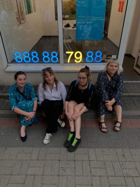 Four women from Feminoteka sitting in front of their facility