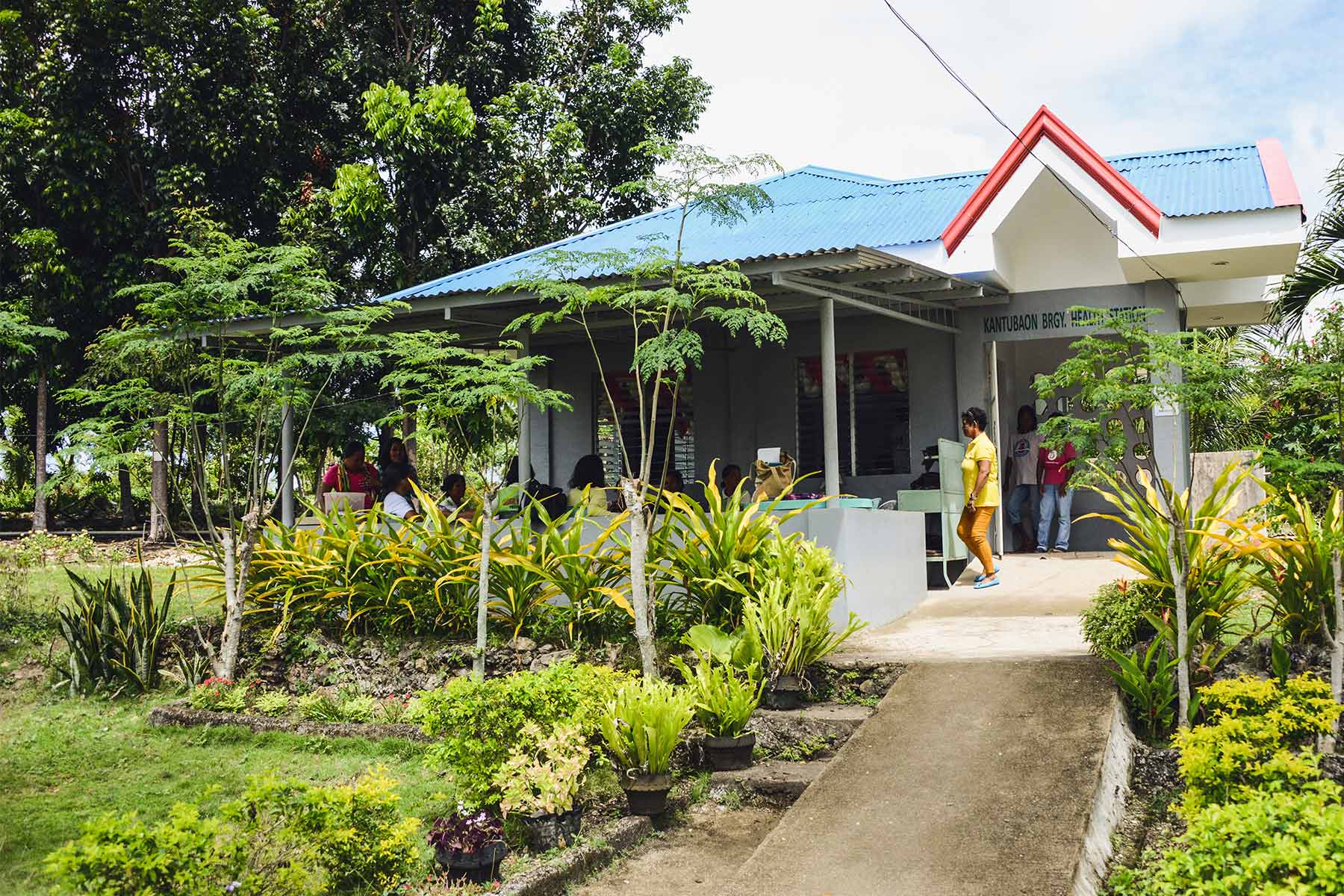 Photo of a small building with people waiting outside.