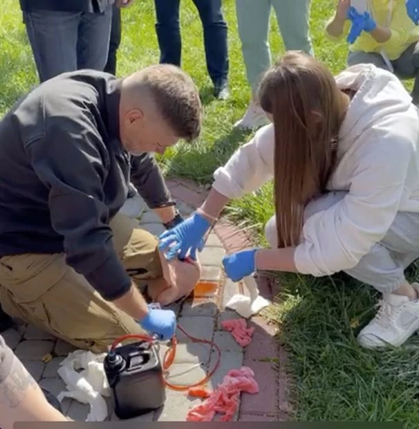 Volunteer being taught the proper way to apply a tourniquet.