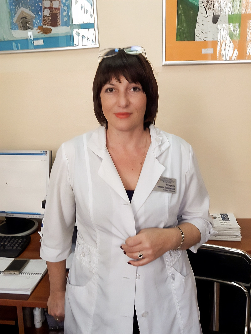 Doctor in white lab coat in office at her hospital.